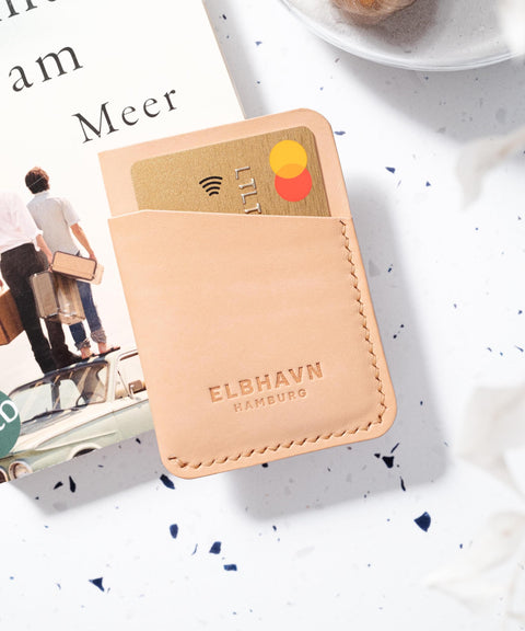 Mini-Kartenetui "Pocket Folio" aus pflanzlich gegerbtem Leder mit Kreditkarte auf modernem Hintergrund.