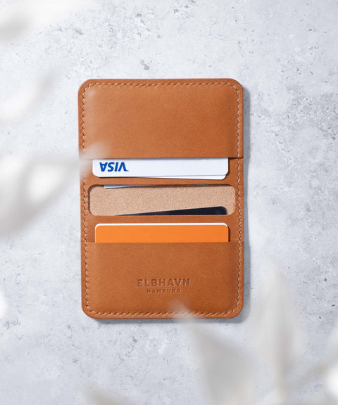 ELBHAVN Folio Wallet in Cognac, gefüllt mit Karten und Scheinen. Handgefertigt in Hamburg. Innenseite, Draufsicht, aufgeschlagen.