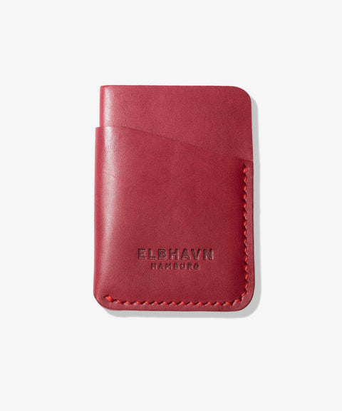 Handgefertigtes rotes Mini-Kartenetui "Pocket Folio" aus pflanzlich gegerbtem Leder von ELBHAVN. Vorderseite auf einem hellgrauen Hintergrund.