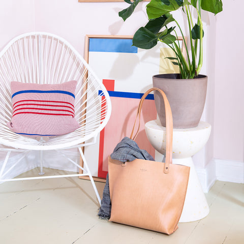 Leder Shopper "Vacchetta Tote Bag" in Naturleder, minimalistisch und elegant, platziert in einem modernen Wohnraum.